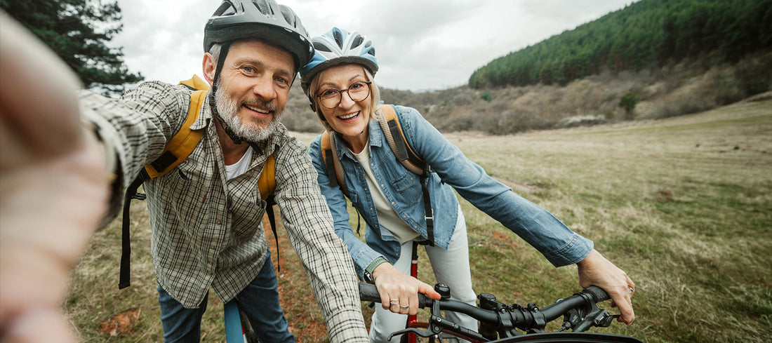 Active man and woman enjoying cycling outdoors and supporting healthy aging and vitality